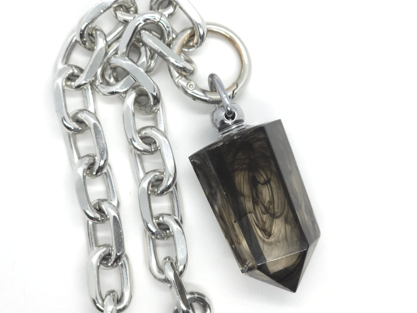 Silver chain with a black stone pendant on a white background