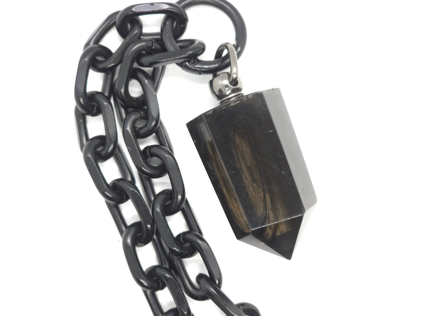 Black chain with a smokey crystal pendant on a white background