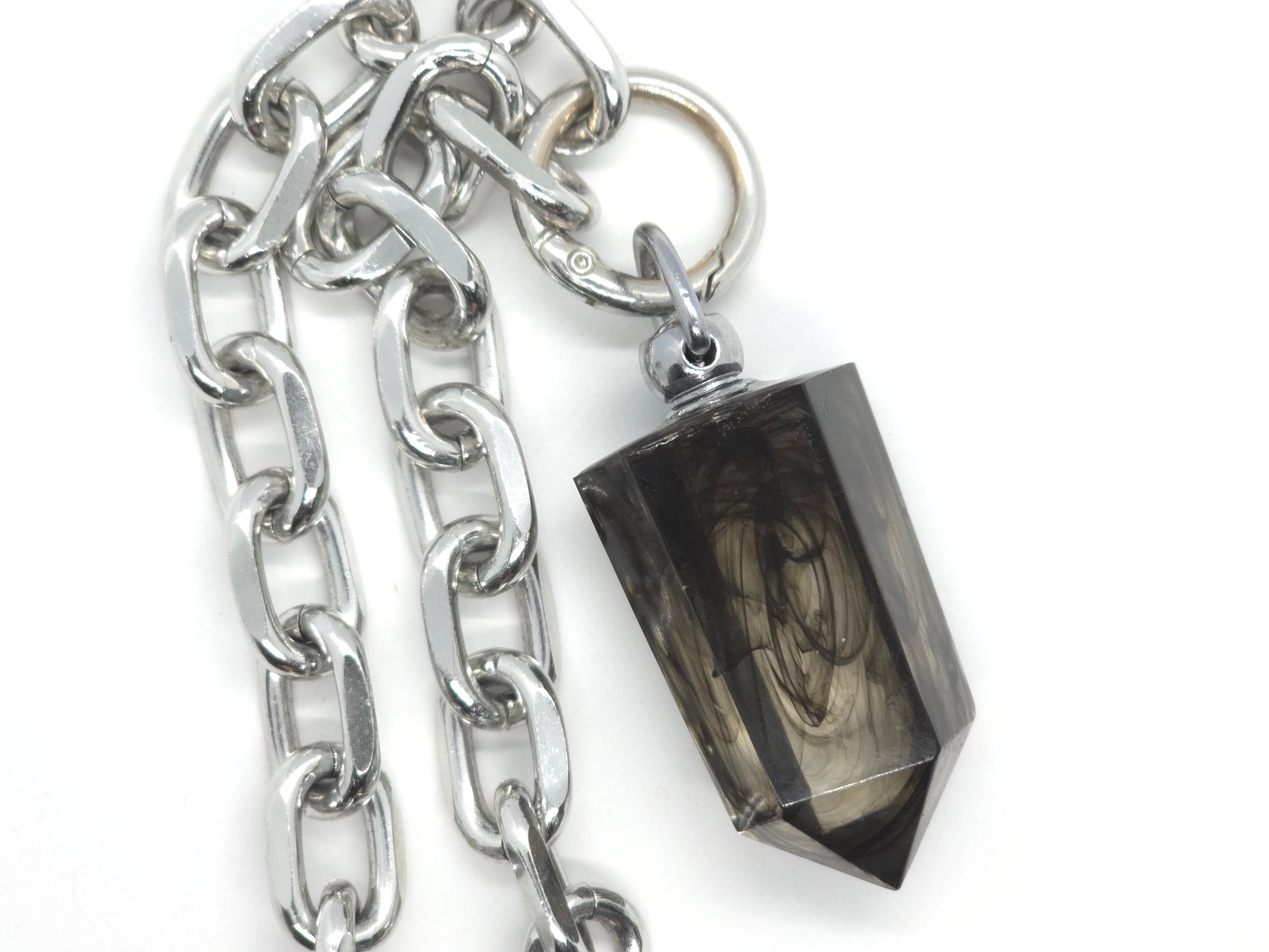 Silver chain with a black stone pendant on a white background